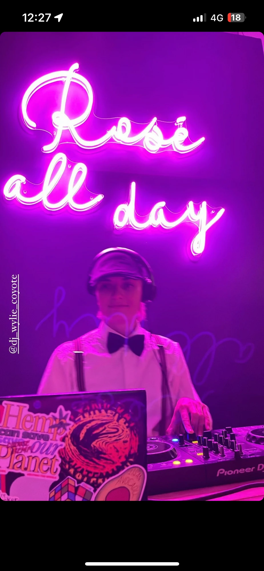 Brooke at the decks under a Rosé All Day neon sign
